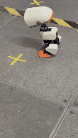 Physical Microduck walking and turning on a tiled floor.